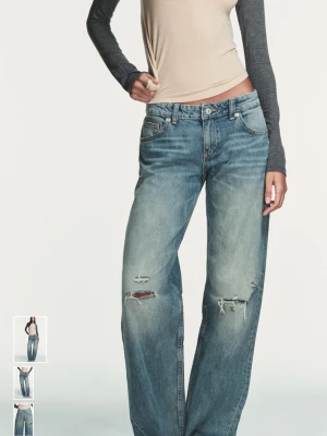 Blå slitna raka jeans - Säljer ett par blå raka jeans med slitningar och hål på både fram- och baksida. Jeansen har en avslappnad passform och klassisk femficksdesign. Perfekta för en cool och avslappnad stil. Materialet är denim i bomull.