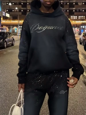 Dogancu Svart loungewear-set med strass - Så snyggt svart loungewear-set från Doganci med hoodie och matchande byxor. Helt slut på hemsida och svårt att få tag på. Endast använd 1 gång. Unisex.