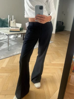 Mörkblå randiga kostymbyxor - Snygga mörkblå kostymbyxor med vita ränder💕endast använda en gång 