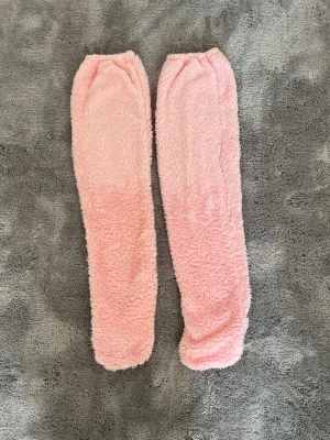 Ljusrosa fluffiga fleece-strumpor - Supermjuka och fluffiga ljusrosa strumpor i fleece som håller fötterna varma under kalla dagar. Även benvärmare. Perfekta att mysa runt i hemma. Långa och heltäckande modell utan synliga detaljer eller mönster.