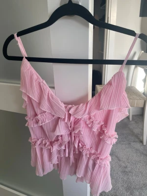 Ljusrosa ribbad linnetopp med volanger - Ljusrosa tröja som är perfekt för somriga dagar. Jag har tyvärr inte fått andväning av den har kanske använt 1 gång. 