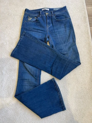 Blå raka jeans från Lee - Snygga blå jeans från Lee med rak passform och klassisk femficksdesign. Jeansen har en liten logotyp på myntfickan och är tillverkade i slitstark denim. Perfekta för en avslappnad och trendig look.