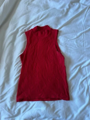 Röd ribbad ärmlös topp från Monki - Säljer en snygg röd ribbad topp från Monki i storlek XXS. Passar xs