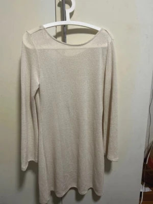 Stickad sommarklänning - Stickad sommarklänning med öppen rygg och snöre vid nacken som går att knyta till en fin rosett. Kan användas som strandklänning över sin bikini då den är någorlunda genomskinlig i material! Storlek L, men passar även större M Pris kan diskuteras vid snabb affär!