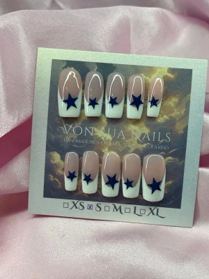 Obsessed (S);Medium Square - Snygga handgjorda press-on naglar i en klassisk fransk design med rosanude bas och vit tipp, dekorerade med mörkblå stjärnor. Naglarna har en rak, medium längd  och är handgjorda i S: 15 mm, 11,5 mm, 12 mm, 11 mm, 9 mm . Perfekt för dig som vill ha en unik och trendig look.