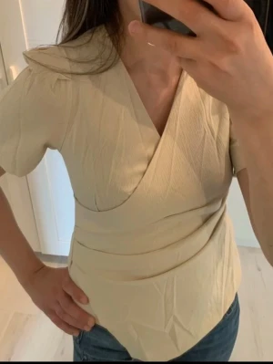 Beige topp SHEIN - Topp från SHEIN, jätte fint skick! Knappt använd, så ser ny ut. Har en kedja på sidan. Beige färg och i storlek S.