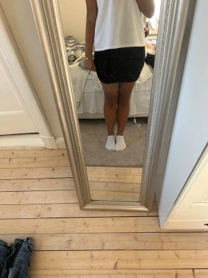 Svart kortkjol i bomull - Säljer en enkel svart kortkjol i mjukt bomullsmaterial. Kjolen har en tight passform och är perfekt för dig som gillar en stilren och basic look. Passar till många olika outfits och är superenkel att matcha.