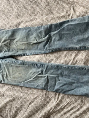 Ljusblå raka jeans från Lager 157 - Säljer ett par ljusblå jeans från Lager 157 med raka ben och klassiska fem fickor. Jeansen har snygga detaljer med ficklock bak och silverfärgade knappar. Perfekta till en avslappnad stil och tillverkade i slitstark denim.