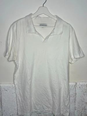 Vit piké t-shirt från S.C.W - Klassisk vit piké t-shirt från S.C.W med krage och kort ärm. Tillverkad i mjuk bomull som känns skön mot huden. Enkel och stilren design som passar till det mesta. Perfekt för dig som gillar en clean och avslappnad look.