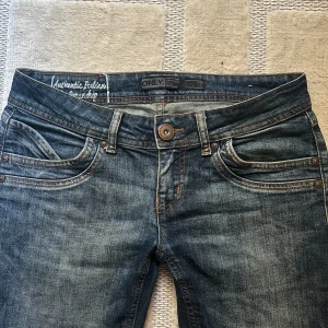 ONLY jeans blå  - Säljer ett par blå bootcut jeans från ONLY med snygga slitningar och kontrastsömmar. Jag säljer för att de tyvärr är för stora för mig. Lånar bilderna från förra ägaren. Köpte ifrån plick innan men har aldrig använt dem. Innebenslängden är 71 cm och midjemåttet tvärs över är 41 cm.