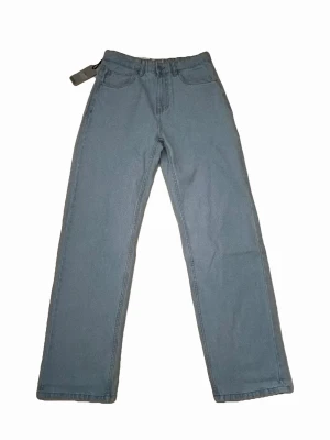 Blå loose fit jeans - Snygga blå jeans med loose fit passform och klassiska fem fickor. Jeansen har ett grått bälte i midjan och är tillverkade i ett mjukt denimtyg. Perfekta för en avslappnad och trendig stil.