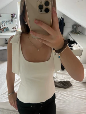 Vit topp från Zara  - Vit topp med rosetter på ärmarna från Zara i storlek xs !! Aldrig använd och lappen är kvar 🤗Pris kan diskuteras vid snabb affär 
