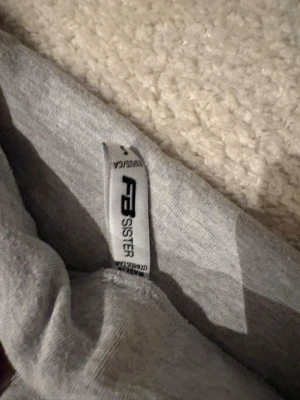Grå mjukisbyxor från FB Sister - Säljer ett par grå mjukisbyxor från newyorker med utsvängda ben och bred linning. Byxorna är tillverkade i mjukt och stretchigt material, perfekta för chill eller hemmabruk. Enkel och stilren design som passar till det mesta. Storlek: S