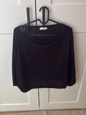 Svart offshoulder topp från Nelly - Snygg svart offshoulder topp från Nelly med lös passform. Toppen är ärmlös och har en bred urringning som sitter snyggt över axlarna. Perfekt att styla med jeans eller kjol för en trendig look.
