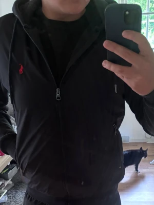 Mörkblå Ralph lauren jacka  - Mörkblå jacka som är med regn material vid magen och hoodie runt. Bilderna tagna är förfärliga men kan skicka andra om du vill. Jackan köpt i New York så att loggan är inte samma som svensk men det går att skanna koden i jackan för att bevisa den är riktigt. Jackan andvänd 3 gånger o är i bra material. Pris går att diskutera 