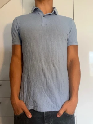 Ljusblå piké från Massimo Dutti - Ljusblå piké i 100% bomull från Massimo Dutti. Strl S. Inga defekter. Modellen är 178 cm och väger 77 kg. Hör gärna av dig vid frågor!