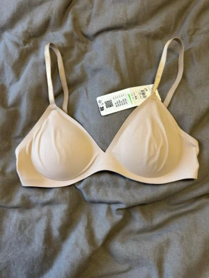 Oanvänd sömlös bh  - Snygg och så skön beige bh med släta, vadderade kupor och justerbara axelband. Modellen är sömlös och har hakknäppning bak för extra komfort. Perfekt under tighta plagg tack vare den diskreta designen. Oanvänd då den tyvärr var för liten🙏🏼 Svårt att översätta storleken men ca 70A-75B 