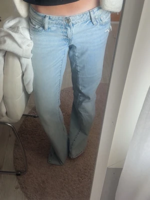 Ljusblå Low waist jeans - Säljer ett par ljusblå lite baggy jeans från Gina tricot. Snygg färg och modell men säljer för de är lite för stora.  De är endast använda ett par gånger, som nya!! (De är väldigt långa, i tall)