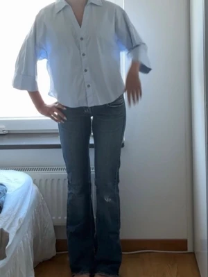 Blå bootcut jeans med slitna detaljer - As snygga lågmidjade blå vintage jeans, har lite slitningar längst ner där bak (sista bilden)  men annars i väldigt bra skick!!❤️❤️innerbenslängd: 87, midjan skulle jag säga är en XS/S