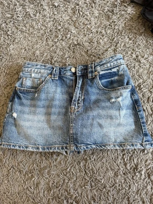 Blå jeanskjol från Stradivarius - Använts 2 gånger. med shorts 