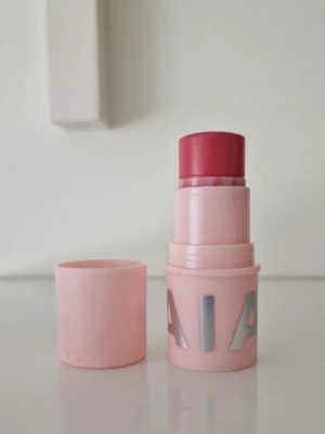 Rosa krämrouge stick från Caia - Säljer ett krämrouge i stickformat från Caia. Färgen Sweet Swirl. Färgen är en djup rosa nyans och hylsan är ljusrosa med silvriga bokstäver. Enkel att applicera direkt på kinderna för en fräsch look. Perfekt att ha i väskan för snabba touch-ups. Endast testad. 