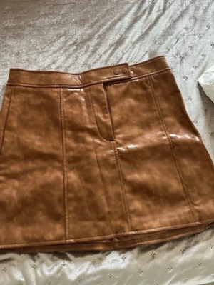 Skinnkjol från H&M - Fin skinnkjol från H&M som bara är använd ett fåtal gånger, har nästan bara legat i garderoben.