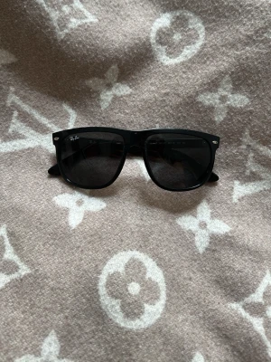 Svarta Ray-Ban Boyfriends solglasögon - Klassiska svarta Boyfriend solglasögon från Ray-Ban med bred båge och mörka glas. Tvär snygg och tidlös design som passar till alla outfits🤩✌️. Ray-Ban-loggan syns på linsen för extra stilpoäng. Nypris 1300kr, skriv för frågor!