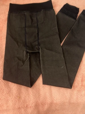 Svarta leggings med inbyggd beige färg innanför. - Svarta leggings som har beige för innanför som gör att man inte behöver frysa när man vill bara uppfixad med kjol eller klänning. Det ser ut som att man bara har på sig svarta stumpbyxor, behöver inte frysa 