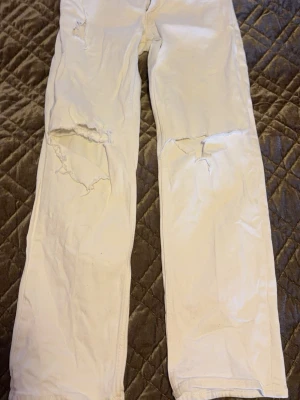 Vita baggy/flared jeans från STAY - Säljer ett par vita jeans från STAY med raka ben och slitna detaljer över knäna. Så snygga men lite för små för mig tyvärr (strl S). Dom är low waisted baggy så så low/mid waisted. 🤗  