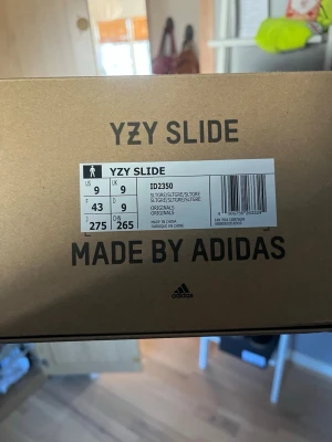 Adidas YZY Slide slate grey - Säljer ett par Adidas YZY Slide i mörkgrå färg. Tofflorna har en chunky, modern design med räfflad sula och är tillverkade i ett mjukt, flexibelt syntetmaterial. Perfekta för en avslappnad och trendig look. Väldigt sparsamt använda och äkthetslapp finns.