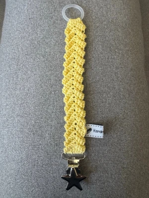 Virkad napphållare  - Virkad, gul napphållare, virkad av mig i 100% bomullsgarn med metallclips och silikonring.  Mönsterskapare: animo.design