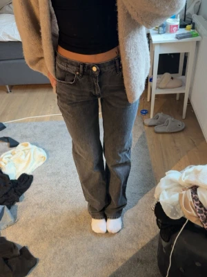 Svarta raka jeans - Säljer ett par svarta raka jeans. Jeansen har en avslappnad passform och stängs med knapp och dragkedja. Perfekta till en enkel topp eller hoodie för en chill look.