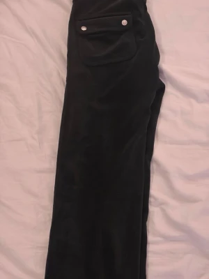 Svarta juicy couture byxor - Svarta juicy couture byxor i storlek xs. Välanvända men bra skick förutom att ena snöret saknas, vilket man troligtvis lätt kan fixa om man är lite hantlig. Sitter snyggt från alla håll och low waist