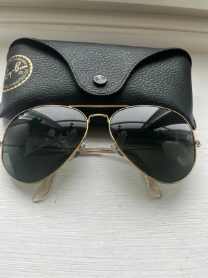 Ray-Ban aviator solglasögon guld - Klassiska Ray-Ban aviator solglasögon med guldfärgad metallbåge och mörka linser. Snygg och tidlös modell som passar till allt. Kommer med original Ray-Ban fodral.