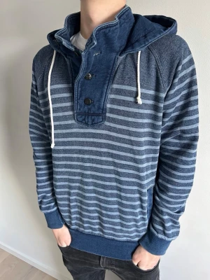 Scotch soda hoodie - Här är en riktigt fet randig halfzip hoodie fast med knappar! Perfekt för dig som vill sticka ut lite. Med frågor eller prisförslag tveka inte på att höra av er!