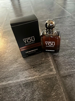 Stronger With You Absolutely parfym - Stronger With You Absolutely från Emporio Armani är en elegant parfym i en mörkbrun glasflaska med silverfärgad kork. Flaskan rymmer 50 ml. En doft som utstrålar lyx och modernitet. Parfymen är helt oanvänd, nypris 1000kr. Vi kan diskutera pris. 