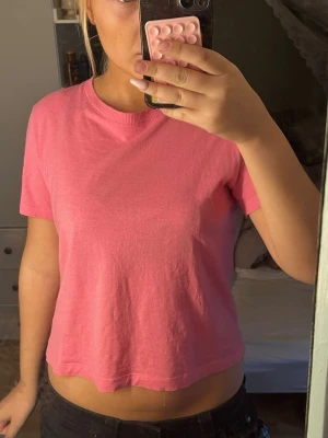 Kort rosa t-shirt från Zara - En enkel och snygg rosa t-shirt med kortare passform och rund halsringning. T-shirten har korta ärmar. Perfekt för dig som gillar en basic och färgglad stil. Super fin till sommaren😍🩷