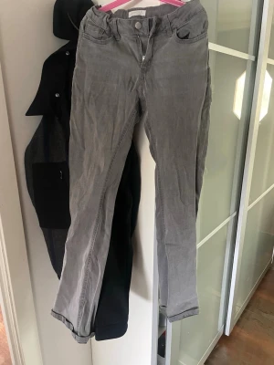 Gråa raka manchesterbyxor - Säljer ett par gråa manchesterbyxor med raka ben och klassisk femficksmodell. Byxorna har dragkedja och knapp framtill samt bakfickor. Perfekta för dig som gillar en avslappnad men ändå stilren look.