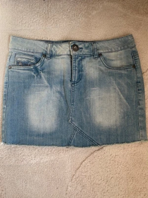 Ljusblå jeanskjol från Only - Säljer en ljusblå jeanskjol från Only! Fem fickor med dragkedja på bakfickorna. Säljer PGA att den är förliten för mig. 🩵Storlek: W28