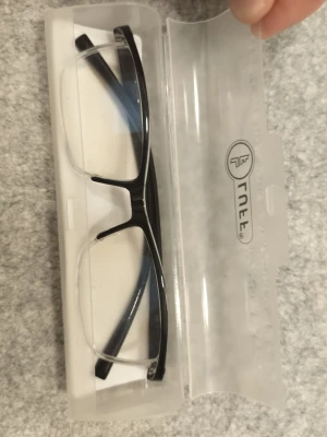 Svarta solglasögon från Arnette - Snygga svarta solglasögon från Arnette med rektangulär form och stilren design. Bågarna är i plast och glasen är genomskinliga, vilket ger en modern och clean look. Perfekta för dig som vill ha en klassisk accessoar till din outfit.