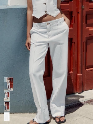 Vita raka jeans med låg midja - Säljer ett par vita jeans med raka ben och låg midja. Jeansen har synliga sömmar framtill, klassisk femficksmodell och stängs med knapp och dragkedja. Perfekta till sommaren för en clean och fräsch look. Helt nya 