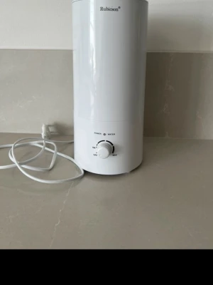 Vit luftfuktare från Rubicson - Säljer en stilren vit luftfuktare från Rubicson. Cylindrisk form med vred för justering av ångnivå och indikatorlampor för ström och vatten. Tillverkad i plast och har en sladd för elanslutning. Perfekt för att förbättra inomhusluften.