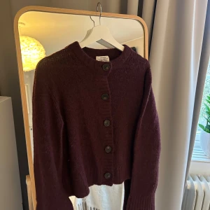 Mörkröd kofta från & Other Stories - Mysig vinröd kofta från & Other Stories med stora svarta knappar framtill. Koftan har rund halsringning. Supersnygg till våren. Använd sparsamt. Pris kan diskuteras. 