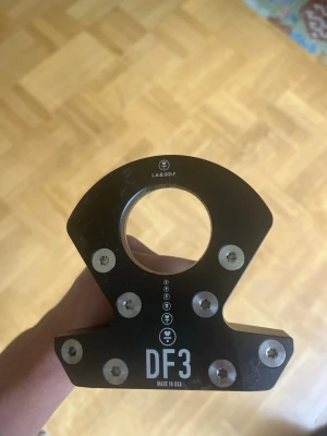  L.A.B. Golf putter DF3 - Säljer en svart putter från L.A.B. Golf, modell DF3. Använd en säsong. Klubban har en unik form med flera synliga skruvar och ett runt hål i klubbhuvudet. Greppet är svart med en vit detalj och hela klubban har en modern, stilren design. Höger grepp. Q meter 