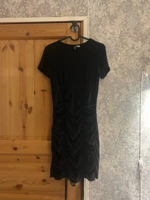 Svart kortklänning med snörning - Svart kortklänning med snörningsdetaljer framtill och korta ärmar från H&M. Mycket bra skick aldrig använd. Hör av vid frågor!💗