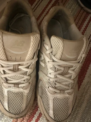 Beige New Balance sneakers 40,5  - Har ett litet hål på vänster sko och lär lite trasigt i tyget vid hälarna :)