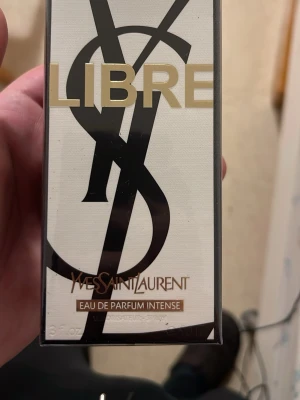Yves Saint Laurent Libre EdP Intense - Yves Saint Laurent Libre Eau de Parfum Intense är en lyxig parfym i elegant svart och guld förpackning. Doften är intensiv och modern, perfekt för dig som vill sticka ut. Flaskan har en stilren design med stora YSL-bokstäver och exklusiv känsla.