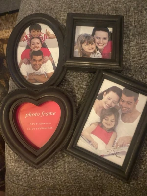 Fyra svarta fotoramar i olika former - Säljer ett set med fyra svarta fotoramar i olika former: oval, hjärta, rektangel och kvadrat. Ramarna är tillverkade i plast och passar foton i storlekarna 10x15 cm och 10x10 cm. Perfekt för att skapa en personlig fotovägg eller ge bort som present.