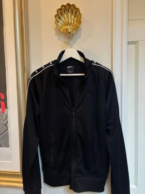 Nike zip tröja  - Svart Nike Zip tröja med stripes längst armarna. 