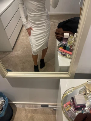 Vit långärmad midiklänning - Snygg vit klänning med lång ärm och kroppsnära passform. Klänningen har en stilren design och slutar strax under knäna. Perfekt för dig som gillar en enkel men elegant look.